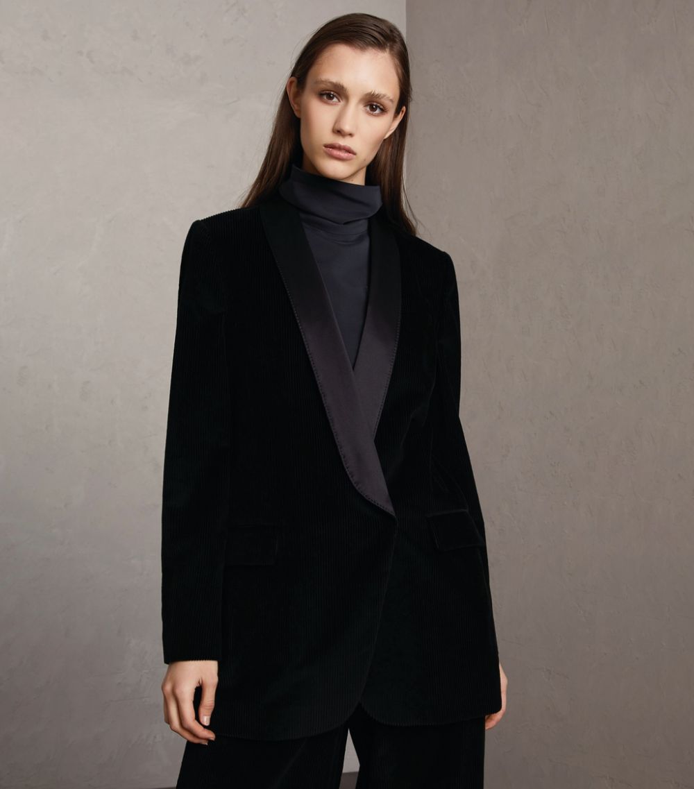 Woman in black turtleneck sweater under velvet blazer